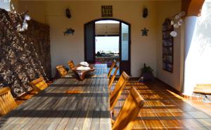 a dining room with a long wooden table and chairs at Villa Azul Fuerteventura in Villaverde