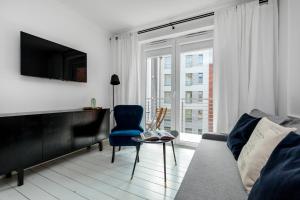 a living room with a couch and a tv at Happy Stay Tartaczna Residence III in Gdańsk