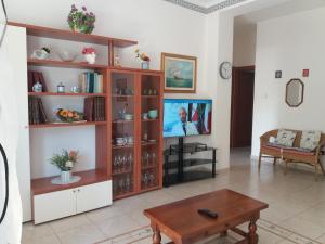Una sala de estar con un televisor y una mesa. en casa vacanze Lida, en Marina di Carrara