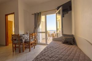 パレオコラにあるPanoramio Paleochora Apartmentsのベッドルーム1室(ベッド1台、海の景色を望むテーブル付)