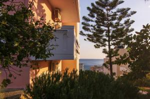 パレオコラにあるPanoramio Paleochora Apartmentsの建物の前に松の木がある建物