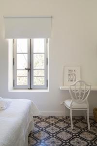 a bedroom with a bed and a chair and a window at Villa Vagabonde in Gordes +42 photos