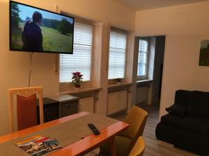 sala de estar con mesa y TV de pantalla plana en Linda en Goslar
