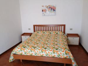una cama con un edredón colorido y 2 mesitas de noche en Villetta Primavera Suna Vista lago CIR10307200215 en Verbania