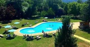 uma piscina num campo com pessoas sentadas à sua volta em Hotel Verdeneve em Opi