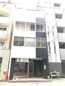 Guest House Re-worth Yabacho1 301 في ناغويا: مبنى أبيض وأسود مع مخزن