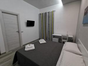 a room with a bed and a table with two towels at B&B La Casa di Pino in Lampedusa