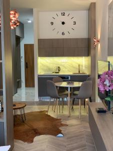 a kitchen with a table and a clock on the wall at Hrebienok 2 Apartman D109 in Smokovce