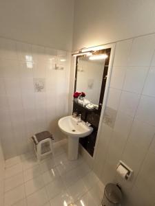 a white bathroom with a sink and a mirror at Wave Marathias Apartments in Marathias