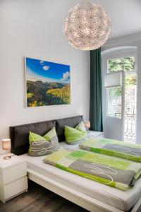 a bedroom with a large bed and a chandelier at Holiday Apartments Wettin in Bad Schandau