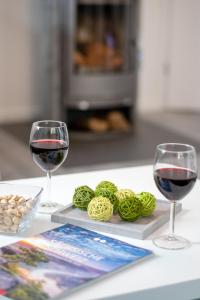 2 Gläser Rotwein und Garn auf dem Tisch in der Unterkunft Holiday Apartments Wettin in Bad Schandau