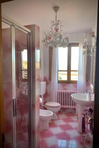 bagno con servizi igienici, lavandino e lampadario pendente. di Dolcevita Chianti Apartments a Radda in Chianti