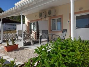 a porch of a house with a table and chairs at Thalassa apartments in Marathias