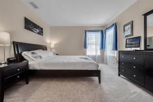 a bedroom with a bed and a dresser and a television at Serene Refuge rent rooms not whole house in Davenport +20 photos