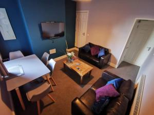 uma sala de estar com um sofá e uma mesa em K Stunning 5 Bed Sleeps 8 Families Workers by Your Night Inn Group em Wolverhampton