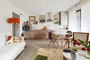 een woonkamer met een witte bank en een tafel bij Le Précieux terrasse 25m2 et parking privé in Aix-en-Provence
