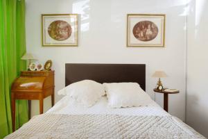 een slaapkamer met een bed met witte lakens en groene gordijnen bij Le Précieux terrasse 25m2 et parking privé in Aix-en-Provence