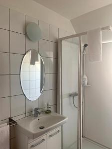 a bathroom with a sink and a mirror and a shower at Mánagisting Guesthouse in Ísafjörður