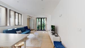 un soggiorno con divano blu e TV di Stunning And Luxurious 3BR Loft 5min From Paris In The Heart Of Boulogne a Boulogne-Billancourt