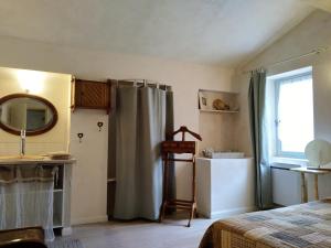 a bedroom with a bed and a mirror and a sink at Côté Chapelle in Coursegoules +42 photos