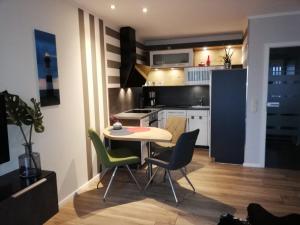 een kleine keuken met een tafel en stoelen in een kamer bij Apartment Enjoy in Büsum