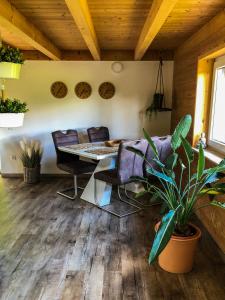 een eetkamer met een tafel en stoelen en een plant bij Surrbach Chalet in Baiersbronn