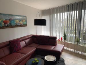 uma sala de estar com um sofá castanho e uma mesa em Apartment Enjoy em Büsum