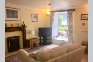 a living room with a couch and a fireplace at TwoStones Self Catering Cottage in Arrochar