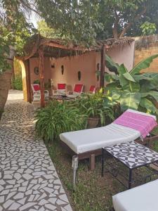 Pokój z łóżkiem i krzesłami na dziedzińcu w obiekcie Mandinka Lodge w mieście Kololi