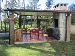 a patio with a fireplace and a table and chairs at Casa do Vale - Seixas in Caminha