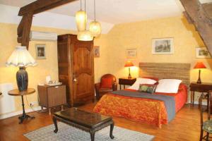 a bedroom with a large bed and a table at chambres d'hotes : La cour d'Etrepy in Le Mesnil-sur-Oger