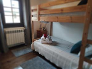 un oso de juguete sentado en una cama en un dormitorio en Casa Dos Nenos, en San Martín