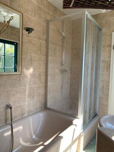 a bathroom with a shower and a white tub at „Rentmeisterhaus Basedow“ in Basedow