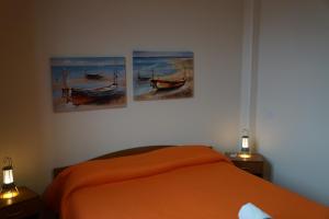 una camera da letto con un letto con tre dipinti sul muro di Casa Vacanze Morselli a Scilla