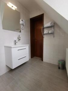 bagno bianco con lavandino e specchio di Hotel Zur Linde a Rommerskirchen