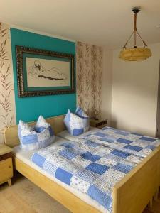 a bedroom with a bed with a blue and white comforter at Ferienwohnung Werratal in Obermaßfeld-Grimmenthal