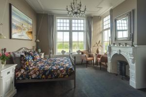 a bedroom with a bed and a fireplace at Pastorie Stella Marie in Oudeschild