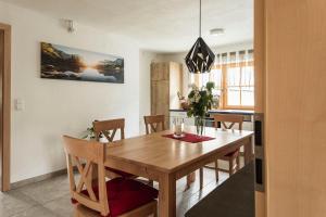 uma sala de jantar com uma mesa de madeira e cadeiras em Haus Enzian em Hinterstoder