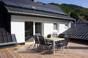 a patio with a table and chairs on a deck at Köpfchen-Ferienwohnungen – Wohnung Belchen in Untermünstertal