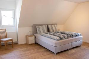 - une chambre avec un lit, une chaise et une fenêtre dans l'établissement Köpfchen-Ferienwohnungen – Wohnung Belchen, à Untermünstertal