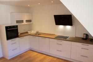 a kitchen with white cabinets and a black appliance at Köpfchen-Ferienwohnungen – Wohnung Belchen in Untermünstertal