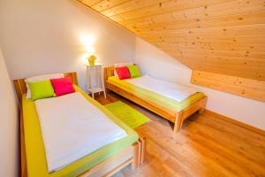 2 łóżka w pokoju z drewnianą podłogą w obiekcie Apartmány Bobrík w Liptowskim Mikulaszu