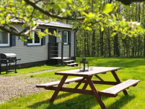 a picnic table in front of a cabin at Odpocznij sobie in Wünschelburg