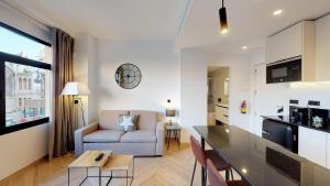 a kitchen and living room with a couch and a table at Goerlich by Alma Suites in Valencia