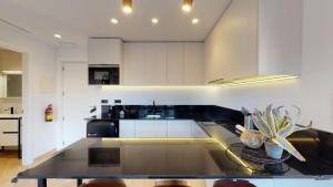 a kitchen with white cabinets and a black counter top at Goerlich by Alma Suites in Valencia