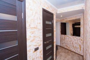 einen begehbaren Kleiderschrank mit einer Holztür in einem Zimmer in der Unterkunft Квартира по ул. Смілянська, 2 (2-й этаж) in Tscherkassy