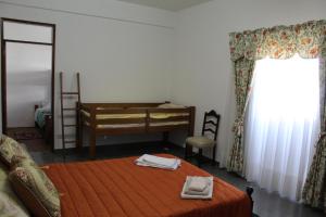 a bedroom with a bed and a desk and a window at Casa do Povo in Gomes Aires