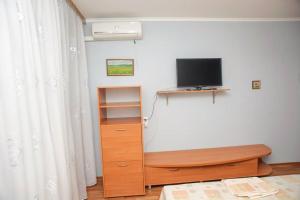 a bedroom with a tv and a dresser with a dresser at ул. Героев Днепра 5, рядом Днепр in Cherkasy