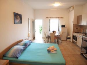 a large bed in a room with a kitchen at Apartments Skorin in Lumbarda