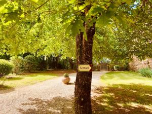um sinal de jardim numa árvore com um sinal nela em La Closerie De Sarlat em Sainte-Nathalène